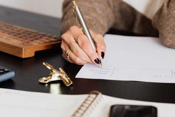 crop-elegant-business-lady-taking-notes-while-sitting-at-4491492.jpg